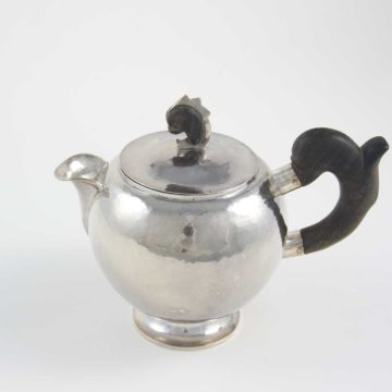 William Waldo Dodge Jr. and Johnny Green, Teapot, circa 1928, hammered silver and ebony wood, 8 × 5 ¾ × 9 ½ inches . Gift of William Waldo Dodge III, 2005.26.03.59. © Estate of William Waldo Dodge Jr.