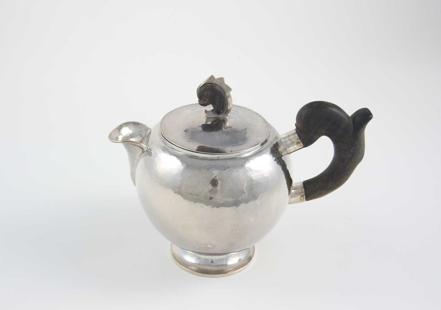 William Waldo Dodge Jr. and Johnny Green, Teapot, circa 1928, hammered silver and ebony wood, 8 × 5 ¾ × 9 ½ inches . Gift of William Waldo Dodge III, 2005.26.03.59. © Estate of William Waldo Dodge Jr.