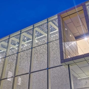 Image of the Asheville Art Museum lit up at night.